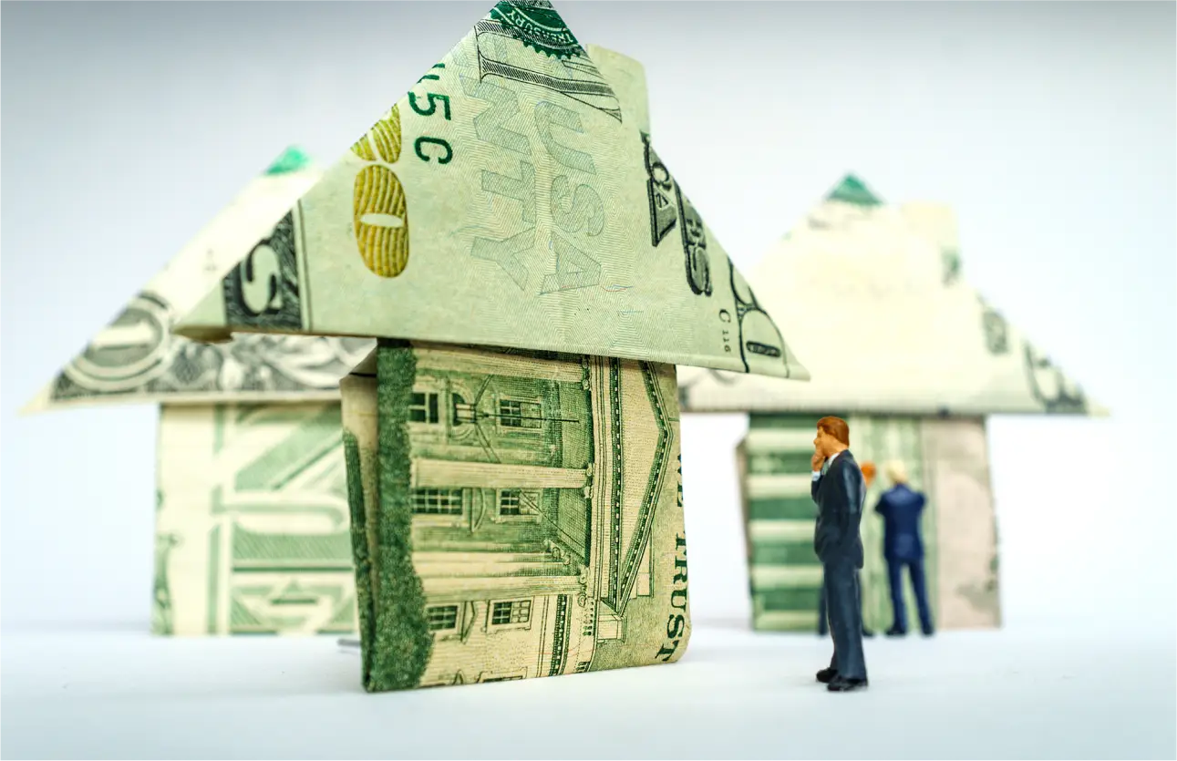 Houses made of money representing motivated home seller leads and the financial opportunities they create for investors