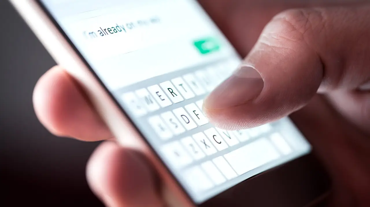 Investor typing a message on a smartphone, illustrating real estate investor text messaging used for lead communication